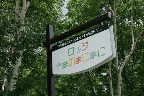 a sign for a park with trees in the background at Okushiga Lodge Yama no Manimani in Yamanouchi