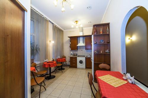 kuchnia i jadalnia z czerwonym stołem i krzesłami w obiekcie Амулет на Малой Морской w Petersburgu