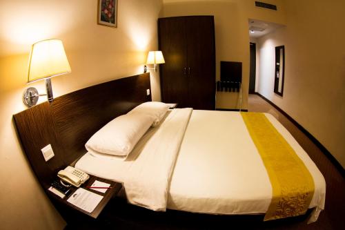 a large bed in a hotel room with a phone at Hotel Tanjong Vista in Kuala Terengganu