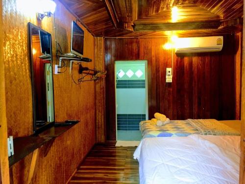 a bedroom with a bed and a tv in a room at Bansuanphuhong Resort in Chiang Khan
