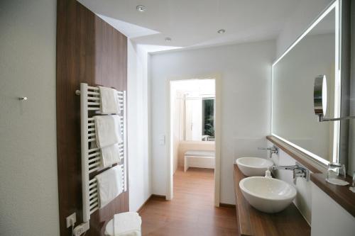 a bathroom with two sinks and a mirror at Badhotel Restaurant Stauferland in Bad Boll