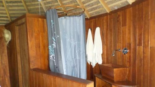 a bathroom with a shower with a blue curtain at Huma Terra Lodges in Hikkaduwa