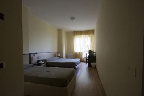 Cette chambre comprend 2 lits et une fenêtre. dans l'établissement Hotel La Fonte, à Osimo
