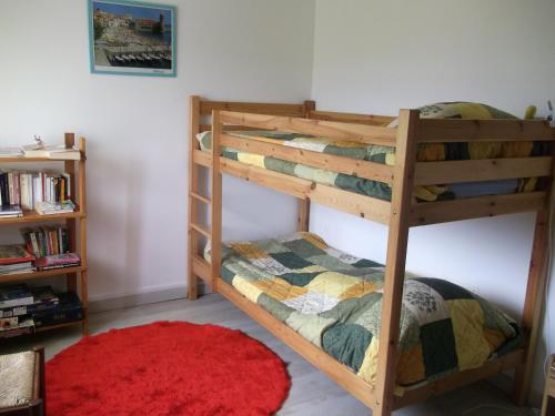 プラードにあるGite LEGRANDのベッドルーム1室(赤い敷物付きの二段ベッド2組付)