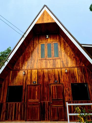 a wooden barn with two doors and a window at Bansuanphuhong Resort in Chiang Khan
