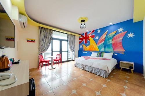 a bedroom with a bed with a painting on the wall at Kenting Aqual Inn in Hengchun