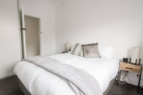 a bedroom with a white bed and a table at 49 Pedder in New Town