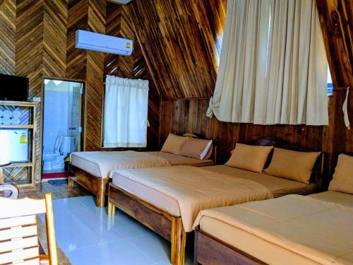 a room with two beds and a tv in it at Bansuanphuhong Resort in Chiang Khan
