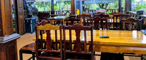 a wooden table and chairs in a room at Bansuanphuhong Resort in Chiang Khan
