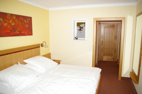 a bedroom with a white bed in a room at Pension Zur Alten Schmiede in Zwiesel