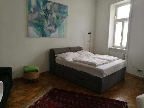 ウィーンにあるJugendstil Garconniereの壁画が飾られた部屋のベッド1台