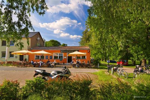 an orange building with a motorcycle parked in front of it at Pension am See in Kremmen