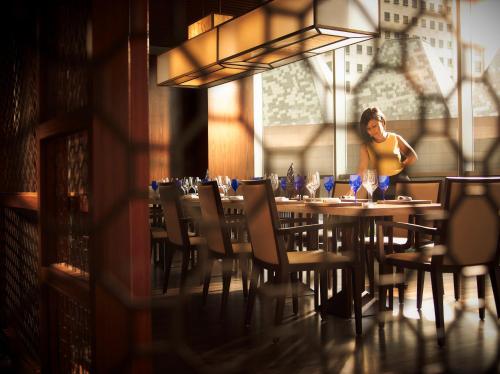 a woman standing at a table in a restaurant at Pan Pacific Singapore in Singapore