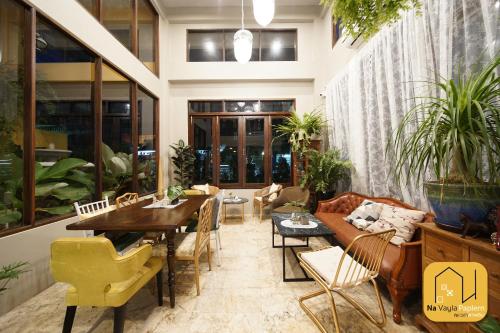 a living room with a couch and tables and chairs at Na Vayla PaPlern in Bangkok