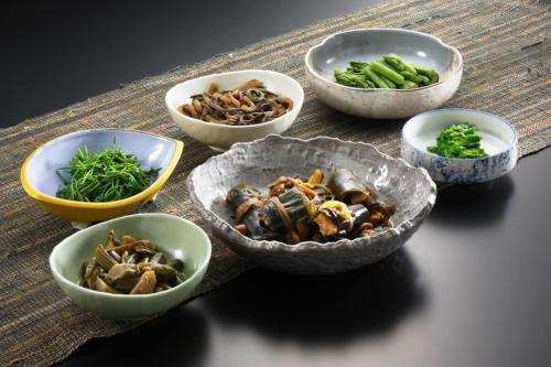 a group of bowls of food on a table at Hot spring inn Snow country(yukiguni) in Tsunan