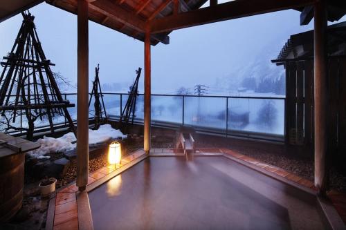 a room with a balcony with a view of a mountain at Hot spring inn Snow country(yukiguni) in Tsunan