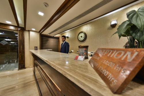 a man standing behind a counter in a restaurant at Clarks inn srinagar in Srinagar