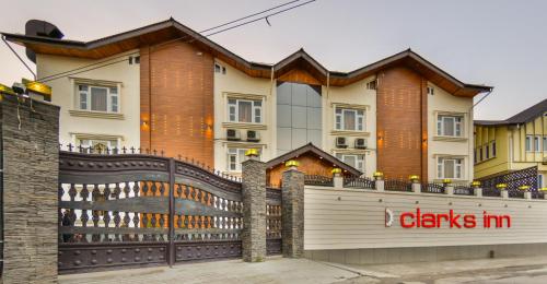 a fence in front of a house with a i clarks in sign at Clarks inn srinagar in Srinagar