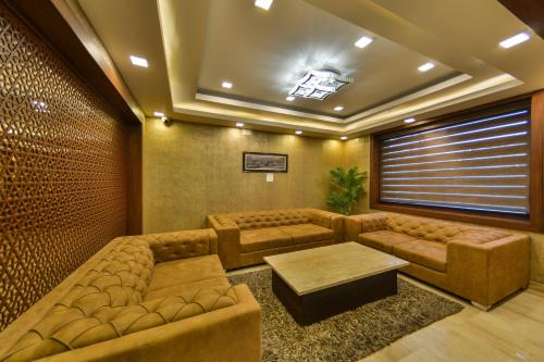 a living room with couches and a table at Clarks inn srinagar in Srinagar