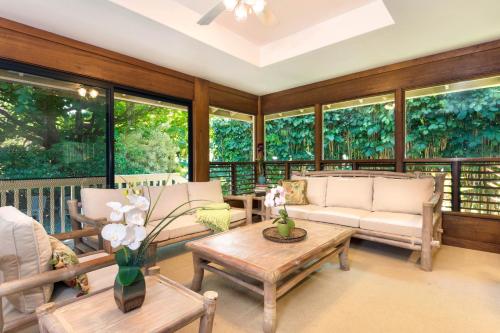 a screened in porch with furniture and windows at Anini Ohana Hale TVNC#4255 in Kilauea