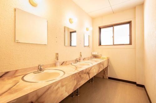 a bathroom with three sinks and a large mirror at Yamanaka Lake Ryozan in Yamanakako