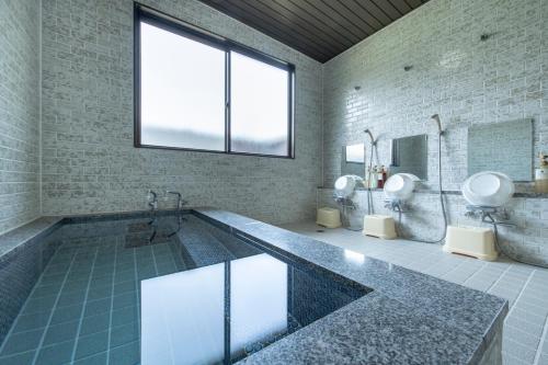a large bathroom with a tub and two toilets at Yamanaka Lake Ryozan in Yamanakako