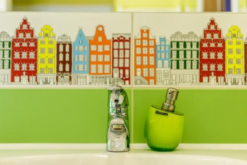 a bathroom counter with a green soap dispenser and a bottle at Smėlynas Klaipėda Lake House in Klaipėda