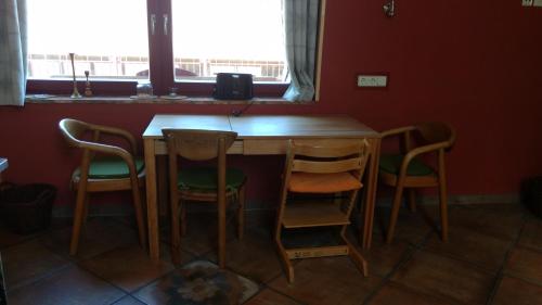 a wooden table and chairs in a room with a window at Ziegeleihof inmitten von Wiesen und Wäldern in Degenershausen