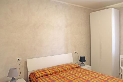 1 dormitorio con 1 cama y 2 lámparas. en Struttura Turistica Villa Calamita en Capoliveri