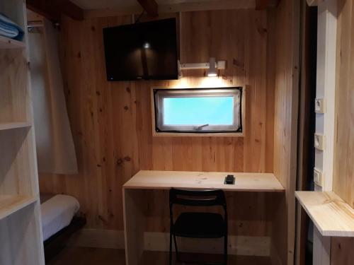 a small kitchen with a desk and a tv in a room at La Masia in Sant Pere Pescador