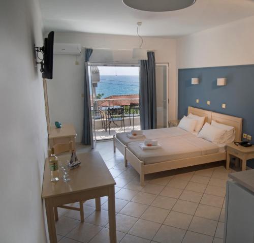 a bedroom with a bed and a view of the ocean at Filanthi Apartments in Paralia Vrachou