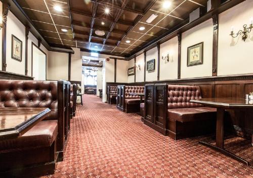 a waiting room with brown leather chairs and tables at Chesterfield Hotel in Trondheim