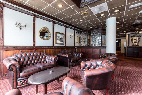 a waiting room with leather couches and chairs at Chesterfield Hotel in Trondheim