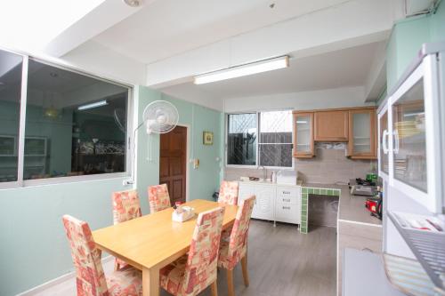 a kitchen and dining room with a wooden table and chairs at The Chan - Sri Ayutthaya Road in Bangkok