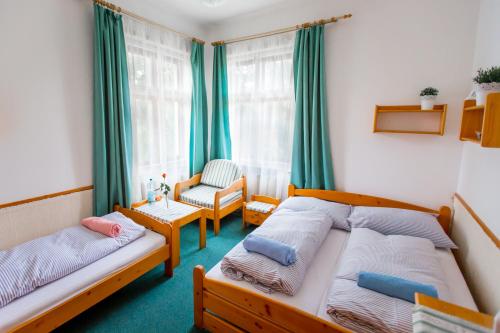 1 dormitorio con 2 camas individuales y 1 silla en Pension65, en Police nad Metují