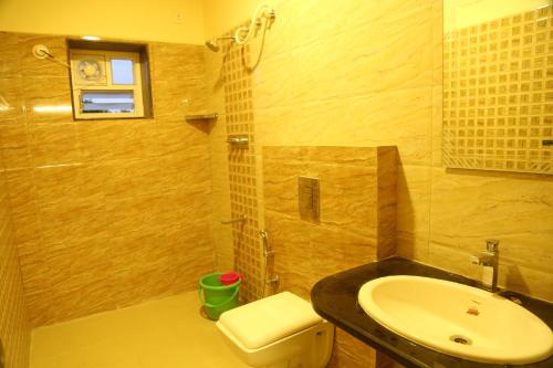 a bathroom with a sink and a toilet at Samarth Residency in Hospet