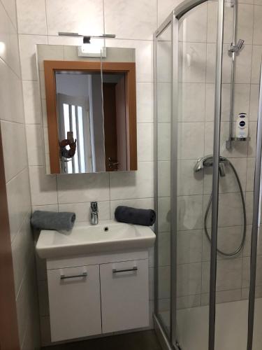 a bathroom with a sink and a shower with a mirror at Karls Ferienwohnung in Teufenbach