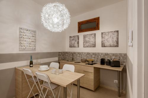 a kitchen with a table and chairs and a chandelier at Stampace Apartments in Cagliari