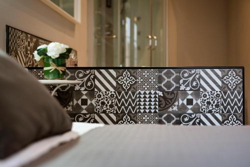 a black and white wall with a vase of flowers at Stampace Apartments in Cagliari