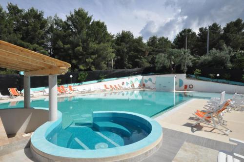 a large swimming pool with a blue swimming pool at Villaggio Elisena in Vieste