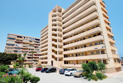 een groot appartementencomplex met auto's geparkeerd op een parkeerplaats bij Apartamento MIRAMAR in Torrevieja