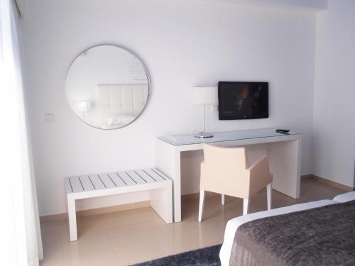a bedroom with a television and a bed at Rocamar Exclusive Hotel & Spa - Adults Only in Albufeira