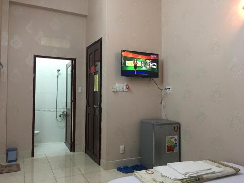a room with a television on the wall and a bathroom at Thu Đô Motel in Vung Tau