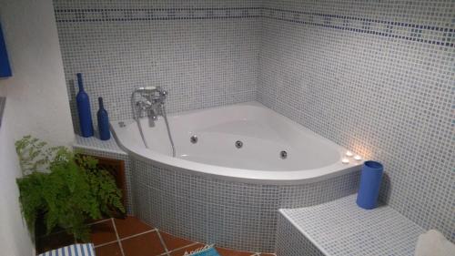 La salle de bains est pourvue d'une baignoire et de carrelage bleu. dans l'établissement Casa con encanto, escapadas románticas (jacuzzi), à Salobreña