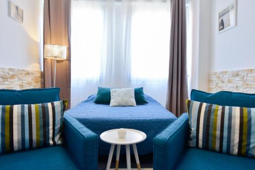 トゥールーズにあるBleue Loft Ramblas Centre Toulouseのベッドルーム1室(青い椅子2脚、ベッド1台、テーブル付)