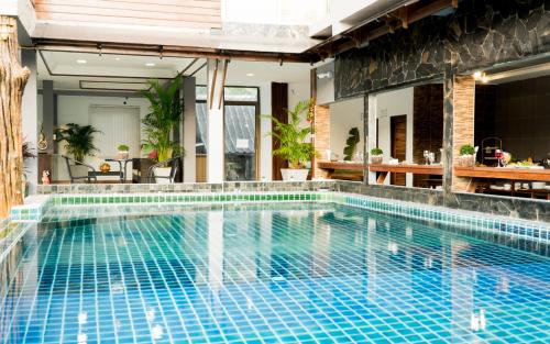 a swimming pool with blue tiles in a house at Billabong Hotel and Cafe in Baan Tai