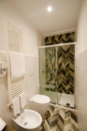 a bathroom with a shower and a toilet and a sink at Riva 33 in Porto Cesareo