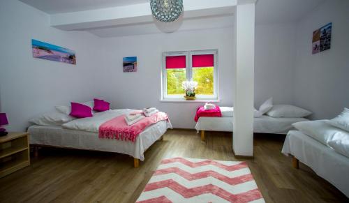 a bedroom with two beds and a window at Apartamenty Piaskowe Rowy in Rowy