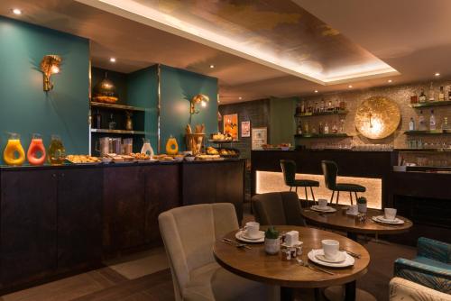 a restaurant with two tables and chairs and a bar at Hôtel La Bourdonnais by Inwood Hotels in Paris