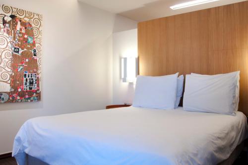 a bedroom with a large bed with white pillows at Capsis Hotel Thessaloniki in Thessaloniki